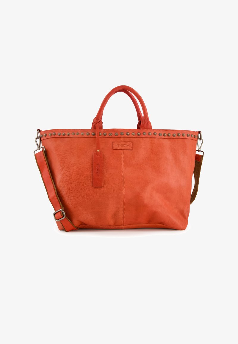 Grand sac fourre-tout en cuir orange avec des clous en métal argenté sur le dessus, des poignées robustes, une bandoulière réglable et une étiquette de marque.