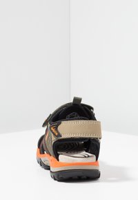 Svart och olivgrön sandal med orange detaljer, andningsbart meshövre, kardborreband och texturerad gummisula för grepp.