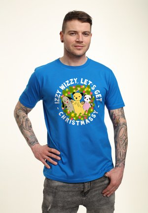 Blauwe T-shirt met korte mouwen, voorzien van een speelse grafiek met drie cartoondieren en de tekst "IZZY WIZZY, Laten we kerstachtig worden!"