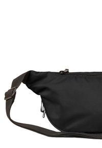 Sort nylon crossbody taske med en struktureret overflade, lynlås i toppen og justerbar stofrem. Har sideløkker for ekstra funktionalitet.