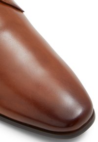 Scarpa da uomo in pelle marrone con una finitura liscia e lucidata. Presenta una punta arrotondata e cuciture minime. Suola in materiale scuro e testurizzato.