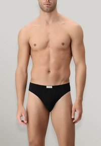 Slip da uomo nero con design a vita bassa, tessuto morbido e una piccola etichetta in vita. Presenta copertura minimale e un taglio base.