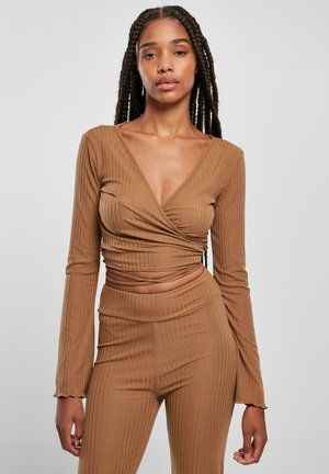 Brown ribbed long-sleeve top features a deep V-neck and wrap design, paired with matching ribbed pants, showcasing a fitted silhouette.