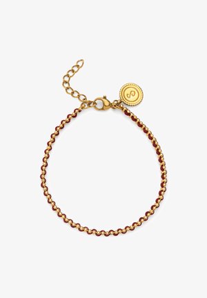 Zlatá retiazka na zápästie s červenými korálkami, obsahujúca klip na homáre a pripojený okrúhly prívesok s vyvýšeným vzorom.