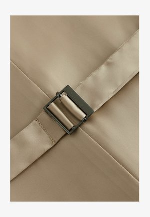 Cinturino in tessuto beige con fibbia metallica rettangolare con finitura satinata, fissato da dettagli cuciti lungo il bordo.