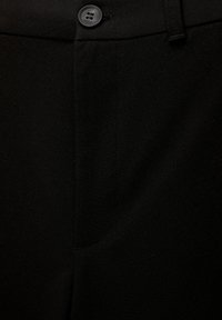 Pantalons noirs avec une texture lisse, présentant un devant plat, une fermeture à un seul bouton et un détail discret de poche latérale.