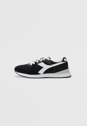 Must have musta sportlik jalanõud valgete aktsentidega, valmistatud võrkkangast ja sukavillast. Sellel on pehmendusega talla ja tekstuuriga kanga hingavus.