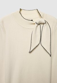 Cremefarbener Pullover mit hohem Kragen, verziert mit einem schwarzen, gerafften Rand und einer gebundenen Schleifendetail. Weicher, glatter Stoff mit einem schlichten Design.