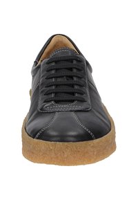 Schwarze Leder-Sneaker mit runder Zehenpartie, strukturierten Schnürsenkeln und einer beigen, gummiartigen Sohle. Mit kontrastierenden weißen Nähten.