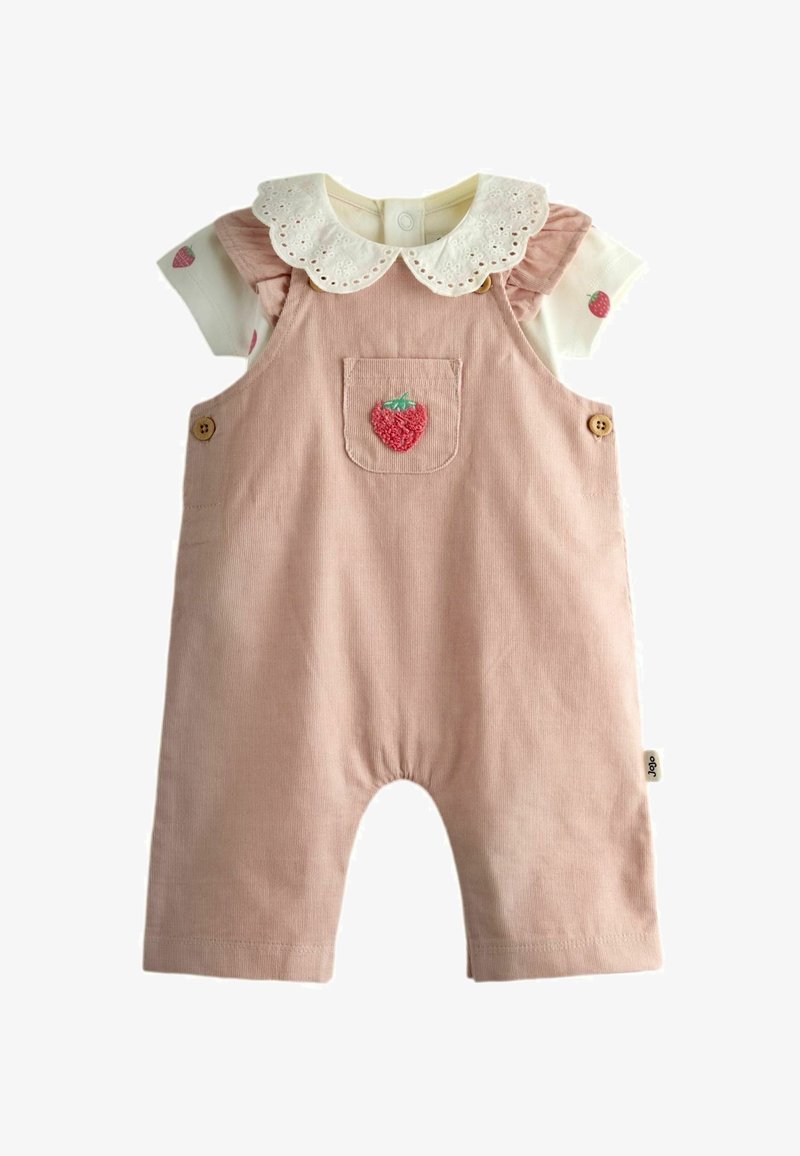 Combinaison rose pour bébé avec une fraise brodée sur la poche avant, portée sur une chemise blanche avec imprimé fraise et col en dentelle ajourée.