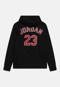 Felpa nera con cappuccio, con il testo "JORDAN" in rosso e bianco e il numero "23" sulla schiena in uno stile pixelato.