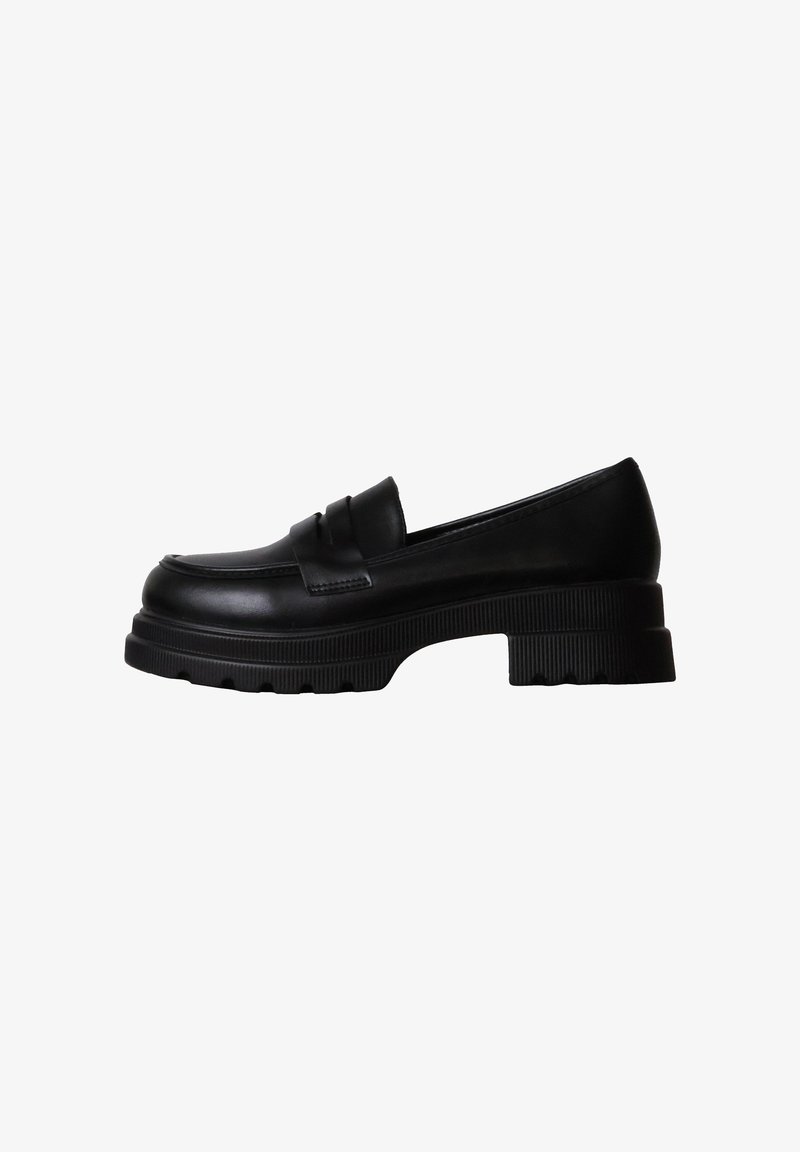 Mocassin en cuir noir avec semelle crantée épaisse et petit talon bloc, vue de côté sur fond blanc.