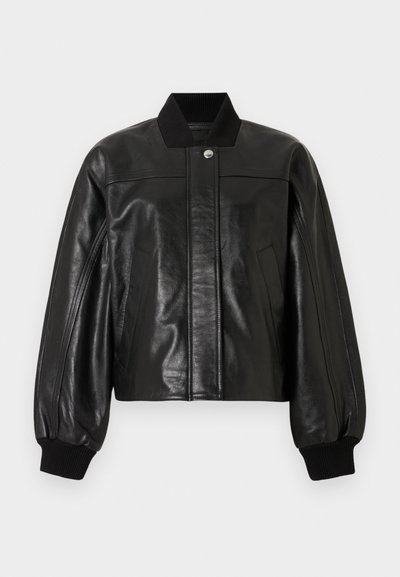 Zwarte leren bomberjack met een geribbelde kraag, ritssluiting en twee voorzakken. Heeft gewatteerde schouders en geribbelde manchetten.