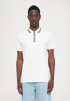 Hvit kortermet polo skjorte med glidelås krage som har røde, blå og brune striper. Stoffet er glatt og lett.