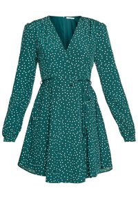 Vestido verde con mangas largas, escote en forma de v, cintura ceñida y falda acampanada. Presenta lunares blancos y un detalle de lazo en la cintura.