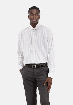 White striped shirt with a bow tie, paired with dark trousers and a textured black belt. Simple button-down design with long sleeves.