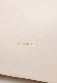 Coccinelle WALLACE - Käsilaukku - off-white/green