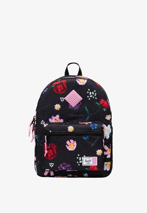 Zwarte rugzak met kleurrijke bloemenprint, voorvak met rits, roze ritstrekkers en een klein roze vierkant textuurpatchje vlak bij het bovenste midden.