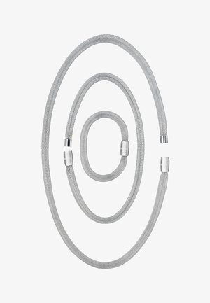 Kolm erineva suurusega hõbedast kootud käevõru, millel on poleeritud metallist kinnitused, graveeritud sõnaga "BREIL," paigutatud valgele taustale.