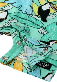 Tkanina w tropikalny wzór z tukany i dużymi liśćmi. Tło w jasnym miętowym kolorze, z metalowymi zapięciami w kolorze srebrnym. Miękki, teksturowany materiał.