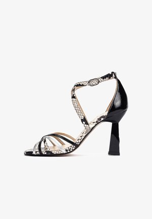 Sandale à talon haut noire et argentée avec un design en cuir verni et peau de serpent, présentant plusieurs brides et un talon carré géométrique.