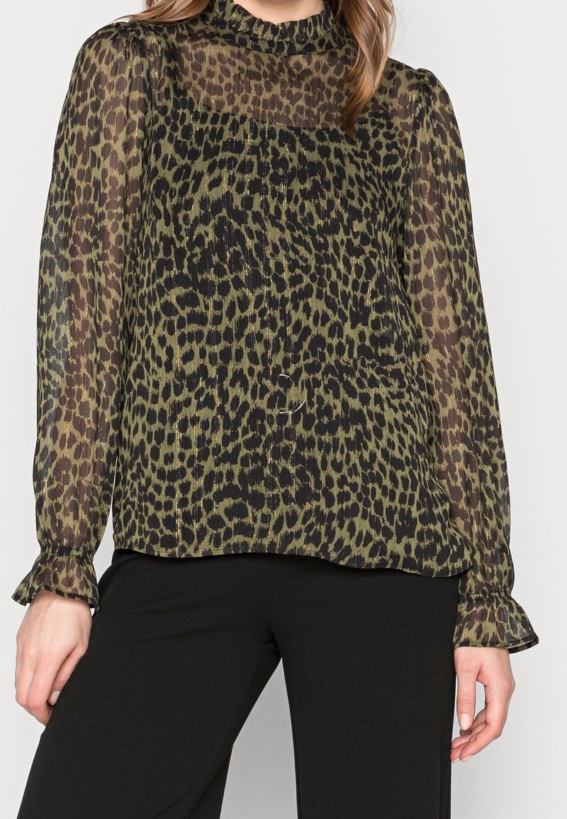 Blouse en voile à manches longues, imprimé léopard olive et noir, avec un col haut et des poignets volantés, offrant une coupe décontractée et une texture légère.