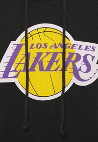 Sweat à capuche noir arborant un logo des Los Angeles Lakers avec un ballon de basketball jaune et un texte violet. Le design comprend des cordons de serrage et un tissu texturé.