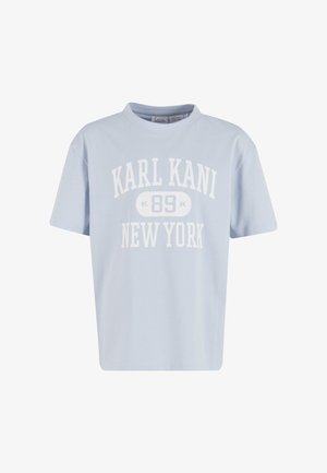 Svetlo modra bombažna majica s kratkimi rokavi, okrolim izrezom in belim grafičnim napisom: "KARL KANI 89 NEW YORK", ki je jasno viden spredaj.