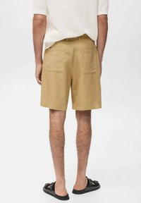 Khaki shorts i bomull med rak passform, två bakfickor och en sl�ät textur, kombinerade med svarta sandaler.