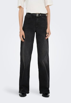 Svarte rette jeans med høy midje, mørkt denimstoff, og kontrasterende sømmer. Kombinert med et svart belte og sølvfarge spenne.