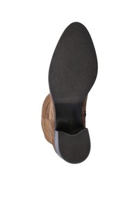 Bruine suède enkellaars vanuit de onderkant weergegeven, met een zwarte, gestructureerde zool en een lage, gestapelde hak op een witte achtergrond.