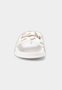 White slide sandal featuring pineapple patterns in orange and green, with the text "Blonde and Proud" in black. Smooth rubber material.