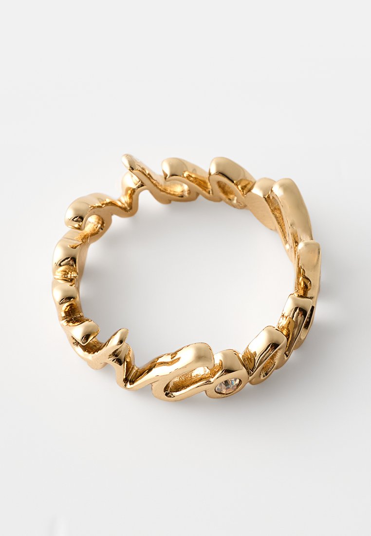 Goldene, gedrehte Metall-Hoops-Ohrstecker mit unregelmäßigen, organischen Formen und einem kleinen, eingefassten klaren Edelstein auf einem weißen Hintergrund.
