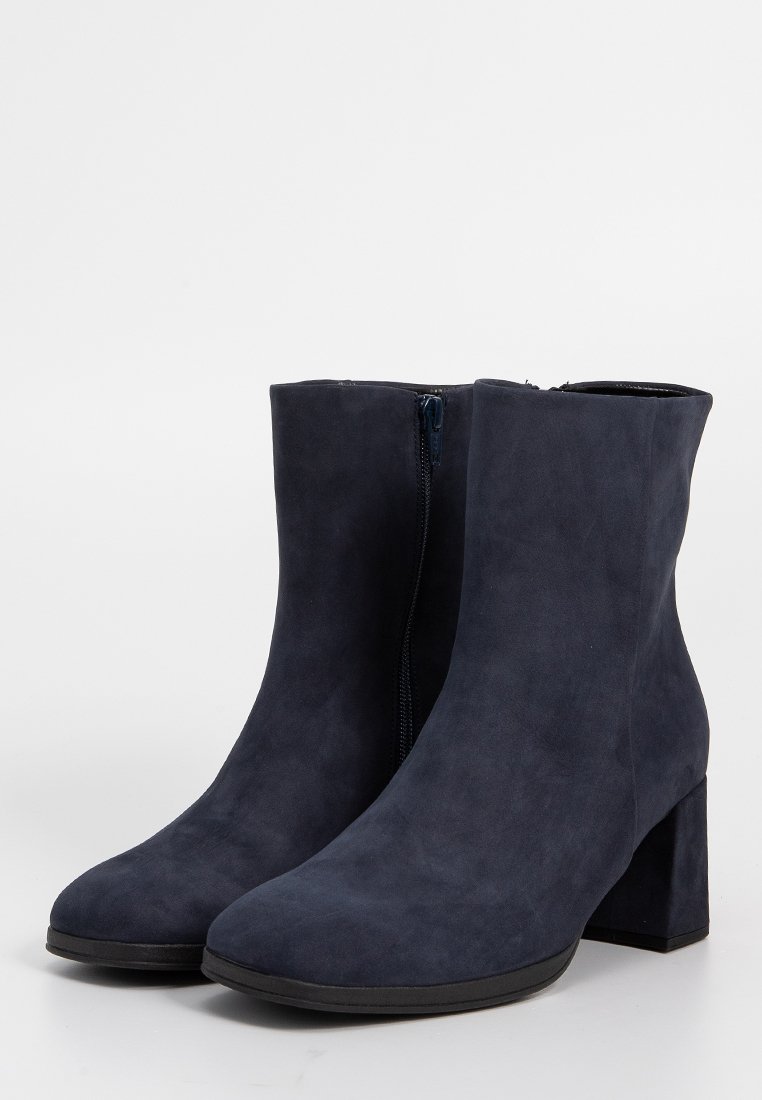 Marineblauwe suède enkellaarzen met een chunkymet zwarte hak en een zijrits. Gladde textuur met een ronde neus en een getailleerde silhoeët.