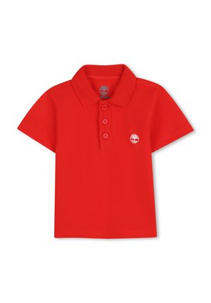 Red polo shirt featuring a collar, three button placket, and a small white logo on the left chest. Made of textured cotton fabric.