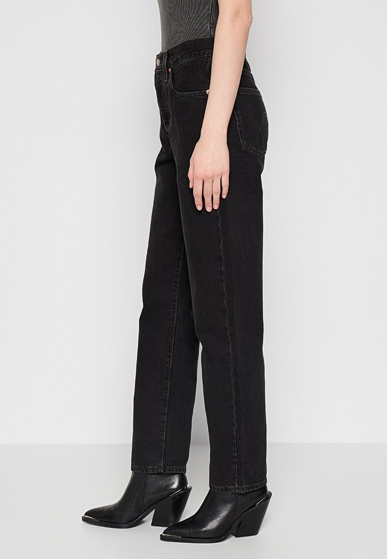 Jeans negros de alta cintura hechos de denim, con un corte recto, cinco bolsillos y detalles de costura sutiles.