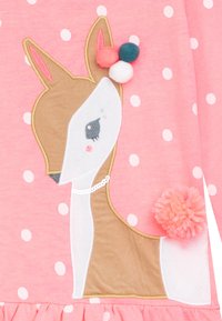 Rotes Kleid aus Stoff mit weißen Pünktchen. Verfügt über ein gesticktes Reh mit beigefarbenen und weißen Details, bunten Pompons und einem Perlenakzent.