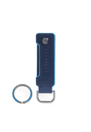 Blauwe leren sleutelhanger met metalen ring en drukknop, met gegraveerde merknaam "Piquadro" op beide delen.