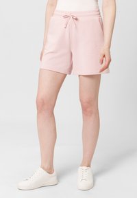 Světle růžové sportovní šortky vyrobené z měkké tkaniny, s elastickým pasem a šňůrkou, bočními kapsami a volným střihem.