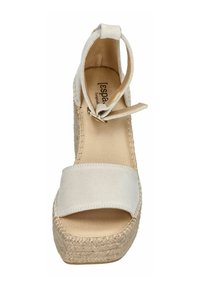 Cream-colored espadrille wedge sandal with a wide suede strap and ankle tie, featuring a woven jute sole. Smooth texture, open design.