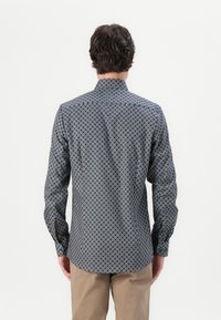 Navy button-down shirt with a geometric pattern, featuring a classic collar and long sleeves, made from smooth fabric.
