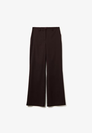 Zwarte, wijde pantalons met riemlussen, voorzakken en een verborgen sluiting aan de voorkant, plat gelegd op een witte achtergrond.