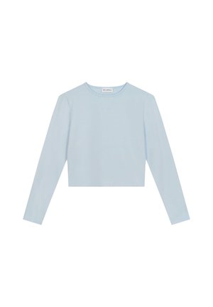 Lyseblå, langermet crop-top laget av mykt stoff. Har rund hals og subtil merkevare på fronten. Enkelt design, uten mønstre.
