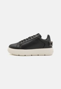 Zwarte leren sneakers met een witte rubberen zool, voorzien van ronde veters, een geperst logo en een metallic accent op de hiel.