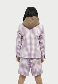 Lila och vit rutiga kostym med en brun huva, som består av en kavaj och matchande shorts. Slät tyg, strömlinjeformat mönster och skräddarsydd passform.