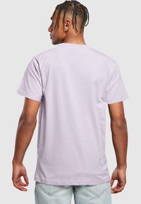 Lavendel bomulds t-shirt med korte ærmer, rund halsudskæring og en afslappet pasform. Bagsiden har et enkelt design uden grafik eller mønstre.