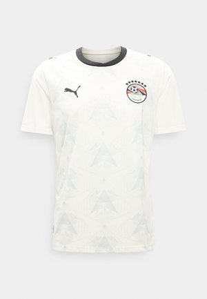 Maillot de football blanc avec col noir, logo Puma noir sur la poitrine droite et écusson de la Fédération égyptienne de football avec étoiles sur la poitrine gauche.