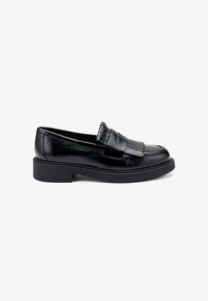 Mocassins en cuir noir avec un petit talon en caoutchouc, présentant une bande frangée sur le dessus. Texture lisse avec une finition brillante.
