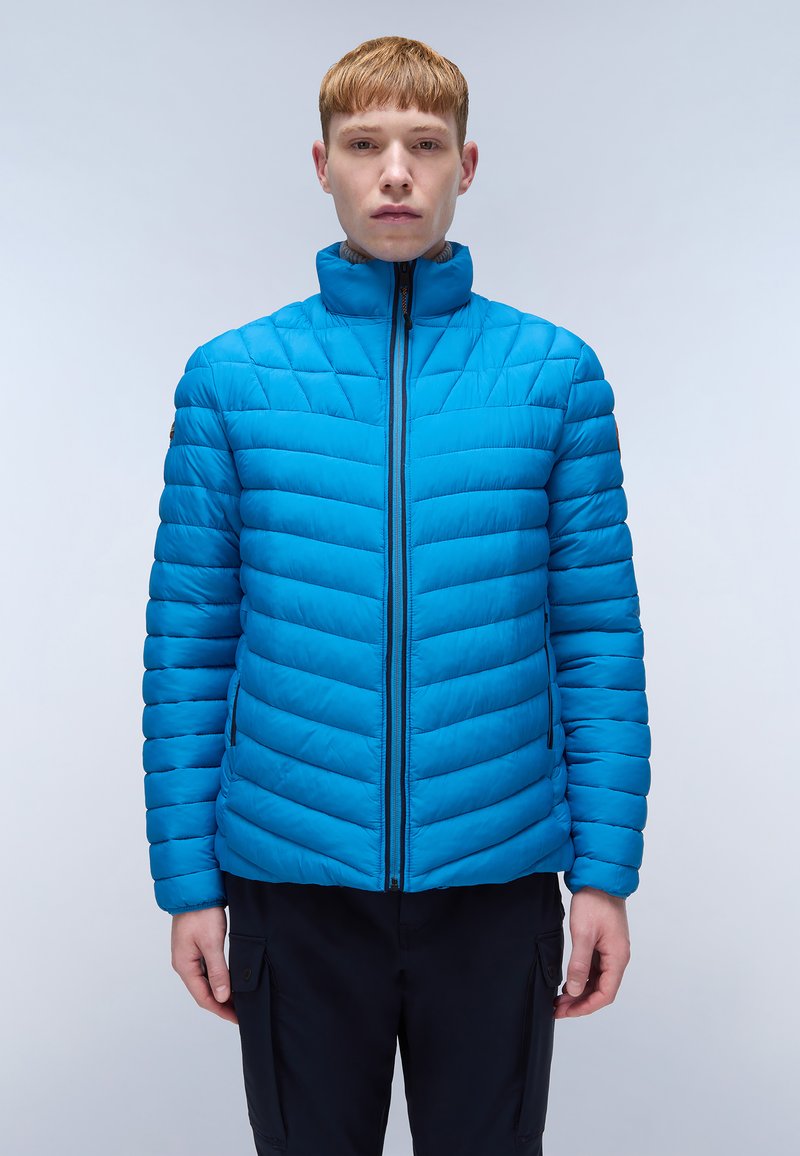 Giacca blu imbottita con colletto alto, motivo trapuntato, linee orizzontali e chiusura con zip. Presenta tasche laterali e una texture morbida.