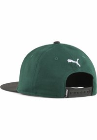 Căciulă din material verde cu margine neagră, având un logo alb Puma pe spate și un închizător ajustabil cu capse. Suprafață texturată și detalii de cusătură vizibile.